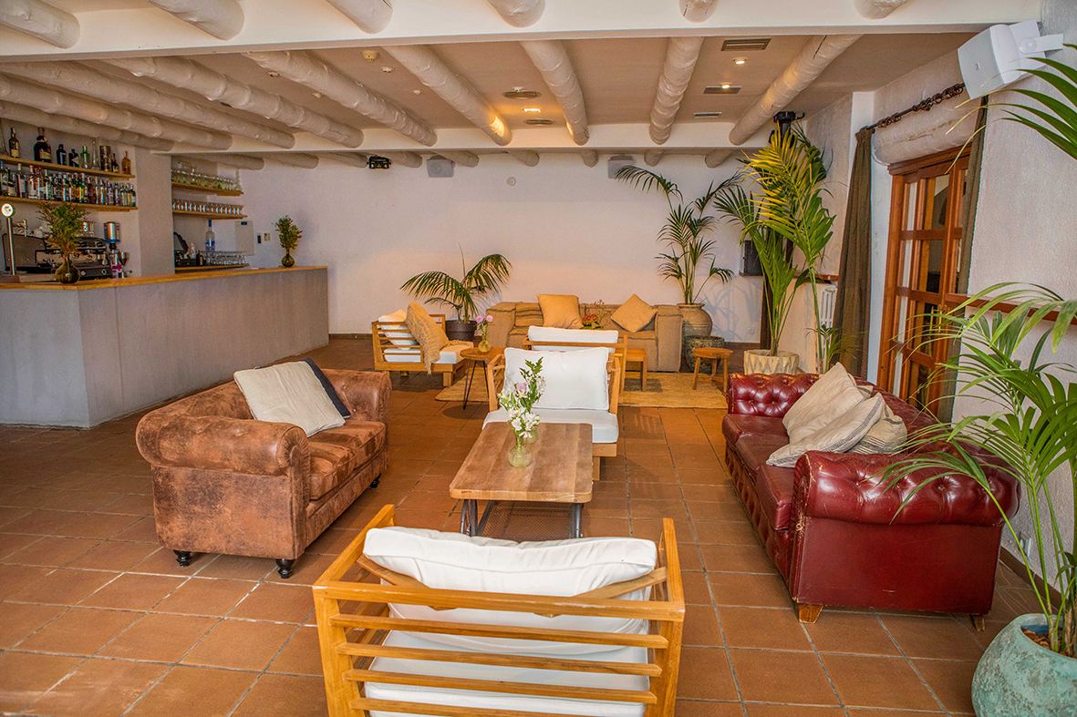 Sala lounge con sofás Chesterfield y barra de bar