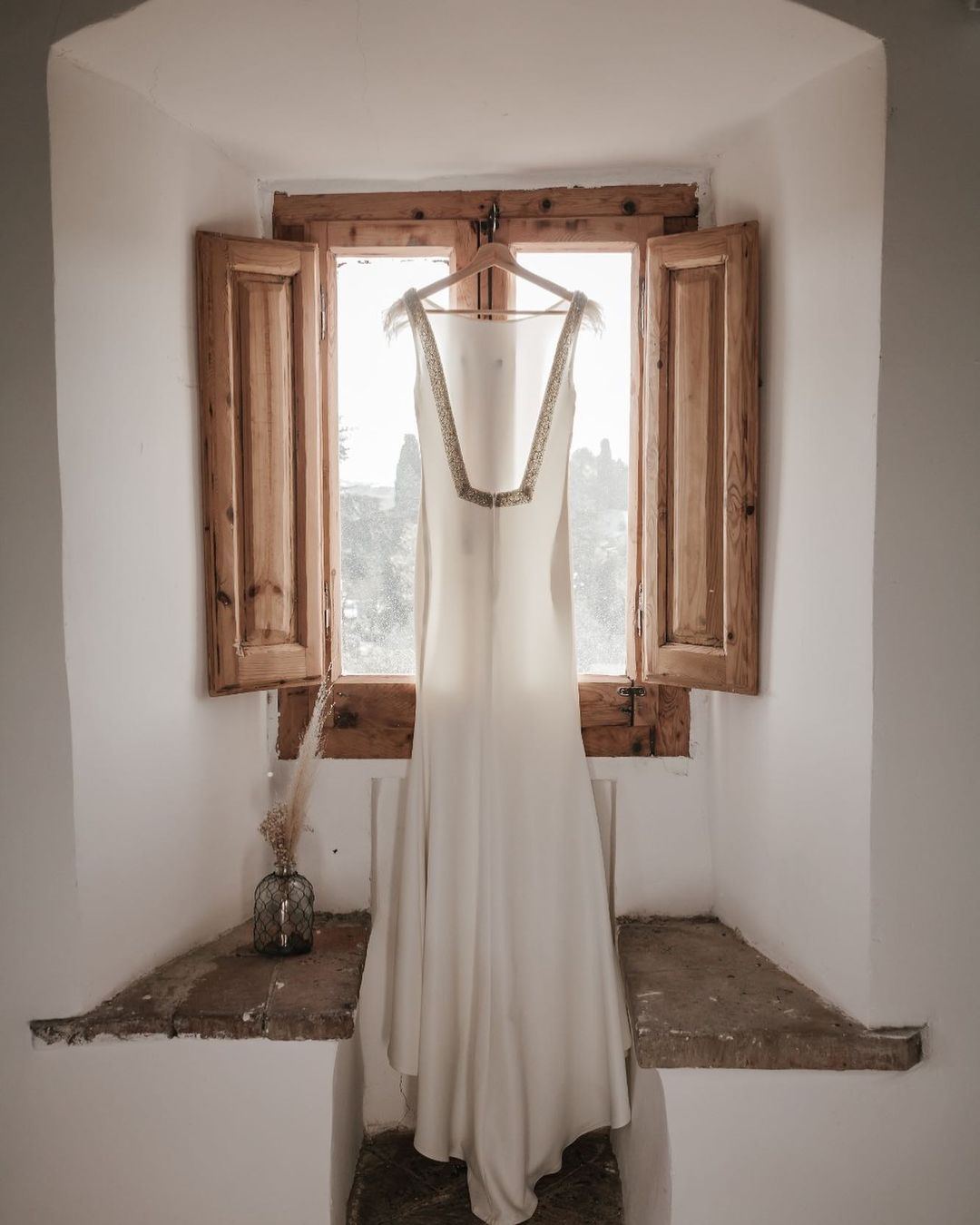 Vestido de novia colgado en la ventana de la torre