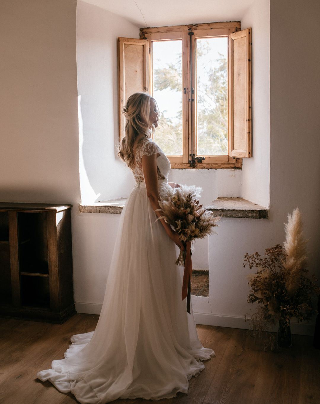 Novia junto a la ventana con su ramo