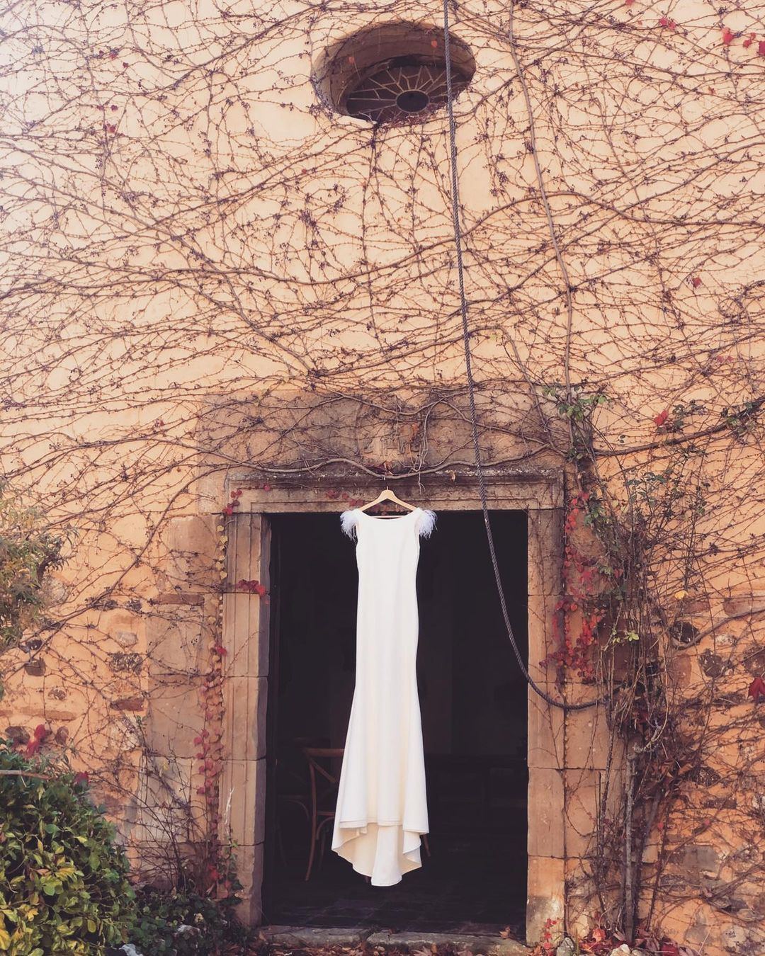 Vestido de novia en la fachada con enredaderas