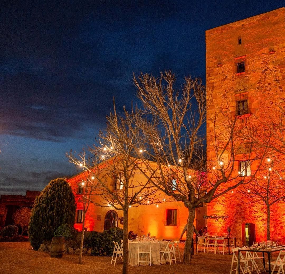 Banquete nocturno iluminado junto a la torre de la masía